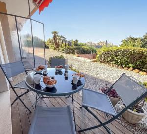 una mesa y sillas en un patio con comida. en Beach, sun, air conditioning and parking in Agay!, en Saint-Raphaël