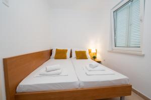 a bed in a room with a window at Apartment Adela II in Novalja
