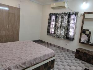 a bedroom with a bed and a mirror and curtains at Jyothi homes in Tirupati