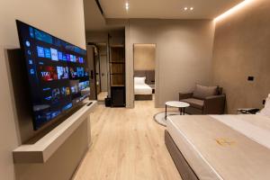 a hotel room with a bed and a flat screen tv at South Inn Hotel in Vlorë