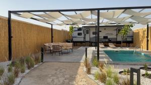 an rv is parked under awning next to a pool at cozy rv in Falaj al Mu‘allá