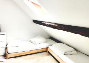 two beds in a room with white walls at Le Duplex de Trouville - central - gare - commerces - marché in Trouville-sur-Mer
