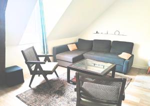 a living room with a couch and a table and chairs at Le Duplex de Trouville - central - gare - commerces - marché in Trouville-sur-Mer