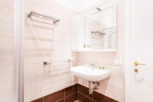 biała łazienka z umywalką i lustrem w obiekcie Magic flat in Duomo by Easylife w Mediolanie +19 zdjęć
