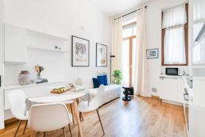 Biały salon ze stołem i krzesłami w obiekcie Magic flat in Duomo by Easylife w Mediolanie