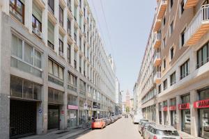 ulica miejska z zaparkowanymi samochodami i budynkami w obiekcie Magic flat in Duomo by Easylife w Mediolanie