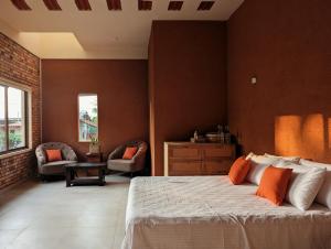 a bedroom with a bed with orange pillows on it at Villa with Private Pool, 12 mins walk to Beach in Trincomalee