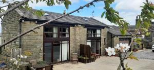 a brick house with black windows and a roof at south view farm cottage 1 Bed in Bradford