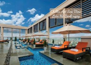 a resort with a pool with chairs and umbrellas at Lux Chillin APT - Căn Hộ Hướng Biển Đà Nẵng in Danang