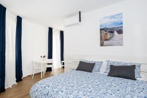 a white bedroom with a bed and a table at B&B Palazzo Diamante in Gravina in Puglia