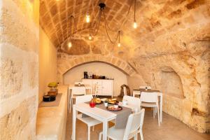 a dining room with white tables and white chairs at B&B Palazzo Diamante in Gravina in Puglia