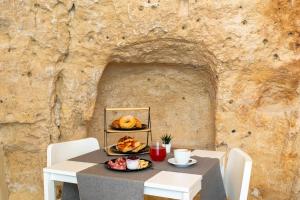 a table with a plate of food on a stone wall at B&B Palazzo Diamante in Gravina in Puglia +35 photos