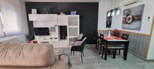 a living room with a couch and a dining room table at Apartamentos Turísticos "El Jardín" in Teruel +37 photos