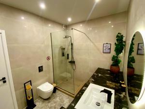 a bathroom with a shower and a toilet and a sink at Stone Luxury Suite in Galatás +21 photos
