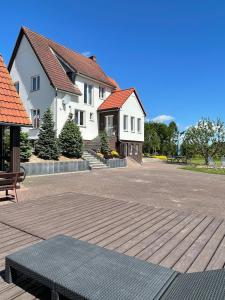a house with a bench on a wooden deck at Agroturystyka in Kościerzyna