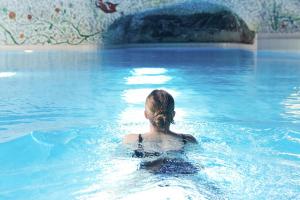 a woman swimming in a swimming pool at Resort Hotel Alex Zermatt in Zermatt