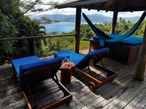 a deck with two chairs and a table with a drink at Latui Lodge in Savusavu