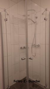 una doccia con una porta in vetro in un bagno di Ferienwohnung Große / Werner a Jüterbog
