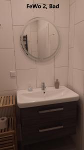 un bagno con lavandino e specchio di Ferienwohnung Große / Werner a Jüterbog