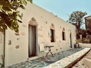 a patio with a table and a chair in front of a building at Stone Luxury Suite in Galatás