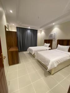 a hotel room with two beds and a window at قاردن وحدات سكنية خاصة in Al Madinah +2 photos