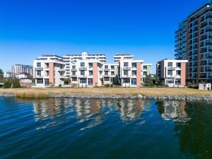 un grand immeuble d'appartements à côté d'une étendue d'eau dans l'établissement Complex Verona Mamaia Nord, à Mamaia Nord – Năvodari