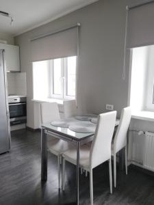 a dining room with a table and white chairs at Küti apartments in Rakvere