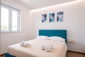 a white bedroom with a bed with towels on it at Da Felicia in Capo dʼOrlando