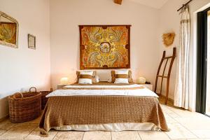 a bedroom with a bed with a large painting on the wall at Auberge de l'Oumède in Saint-Tropez +60 photos