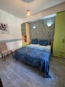 a bedroom with a bed and a brick wall at B&B Il Giardino Diamante in Diamante