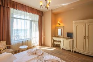 une chambre avec un lit, un bureau et une fenêtre dans l'établissement Complex Verona Mamaia Nord, à Mamaia Nord – Năvodari