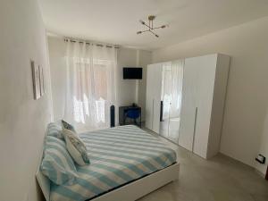 una camera da letto bianca con un letto e una finestra di Casa Marea - Lerici Center a Lerici