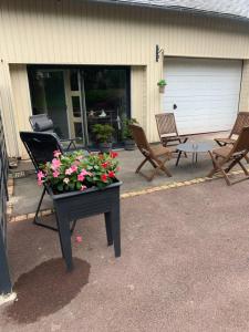 a patio with chairs and a table with flowers on it at Maison de la Rébergère in Javené