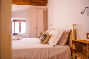 a bedroom with a bed with white sheets and pillows at Agriturismo Tenute Mauro in Ispica +34 photos