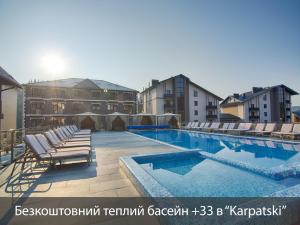 a large swimming pool with lounge chairs on a building at MK Resort (ex. Magiya Karpat) in Bukovel