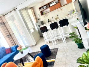 a living room with a blue couch and black chairs at Roje's Oasis in Jinja