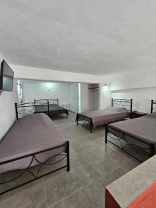 um quarto com três camas e uma TV de tela plana em Porto Castello em Fira mais 37 fotografias