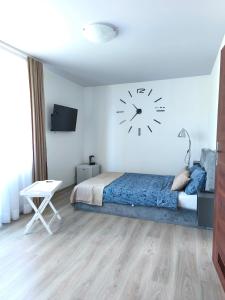 a bedroom with a bed and a clock on the wall at Być Morze in Mrzeżyno