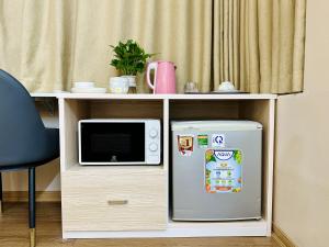 a microwave and a refrigerator next to a desk at Vietnam Travelers Home 2 with Cozy Private Balcony in Hanoi