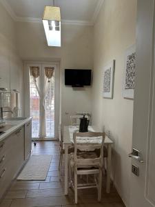 a kitchen with a table and chairs and a television at Charm & comfort in Nettuno