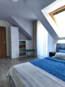 a bedroom with a bed with a blue comforter at Być Morze in Mrzeżyno
