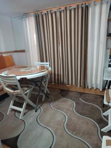a room with a table and a chair and a radiator at Bolero apartman in Sarajevo