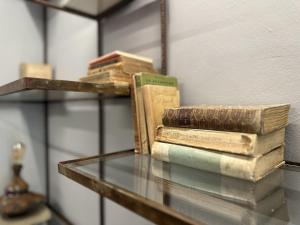 Ein Stapel Bücher liegt auf einem Glastisch in der Unterkunft Locanda 3848 in Pitigliano