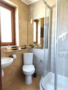 a bathroom with a toilet and a sink and a shower at Być Morze in Mrzeżyno +27 photos
