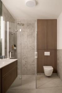 a bathroom with a shower and a toilet and a sink at Piwna Apartamenty nad morzem Władysławowo in Władysławowo