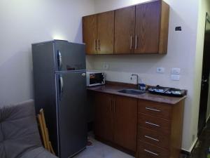 a kitchen with a black refrigerator and a sink at Cecelia Resort - Studio chalet in Hurghada