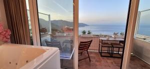 a bathroom with a balcony with a view of the ocean at Suite Imperial in Taormina