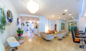 a salon with a waiting room with chairs and tables at Hotel Las Vegas in Bibione