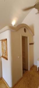 an empty room with a white wall and a door at Aliori art caves in Aegiali