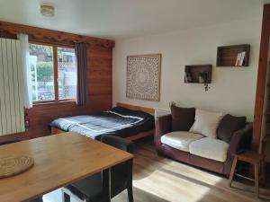 a living room with a couch and a bed and a table at Les Chalets d'Arlos in Arlos